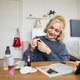 Portrait of beautiful young woman, content creator for social media, sitting in front of digital